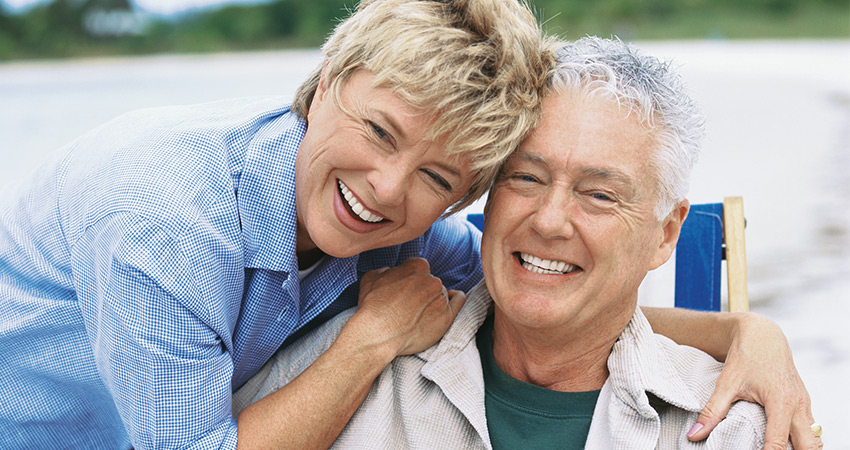 happy caucasian couple heads together smiling showing teeth