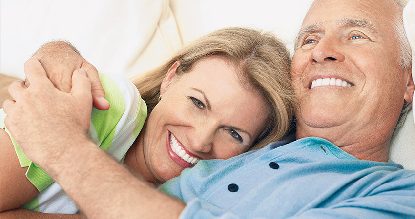 Cute retired couple snuggling and smiling