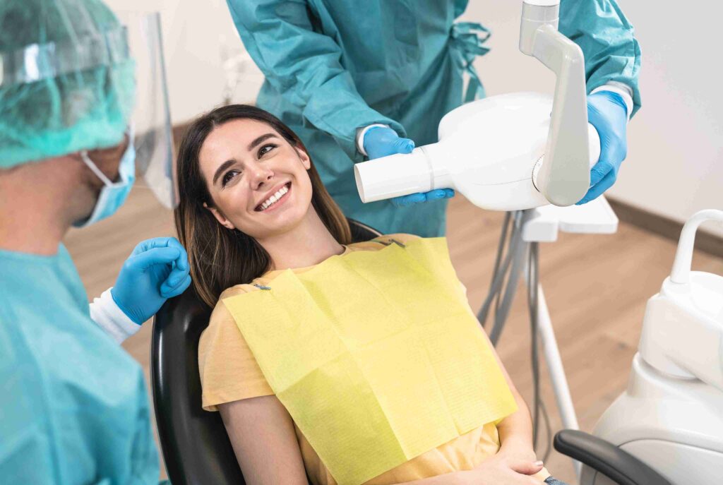 Patient smiling during a dental X-ray consultation.