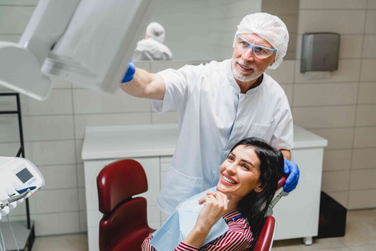 Dentist reviewing dental imaging with a smiling patient.
