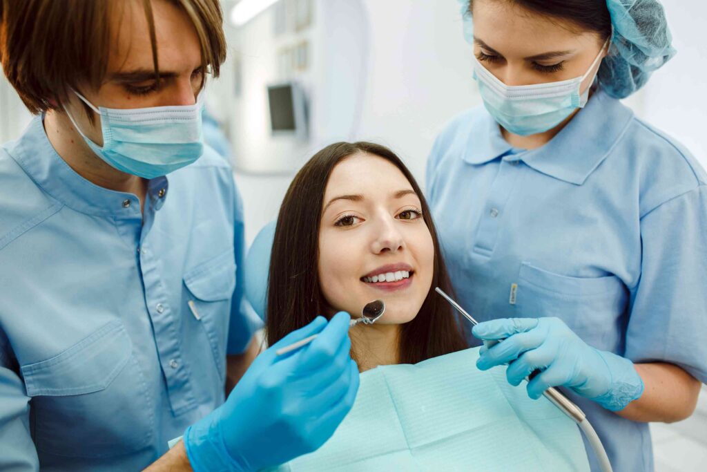 Patient receiving a routine dental examination from two dental professionals.