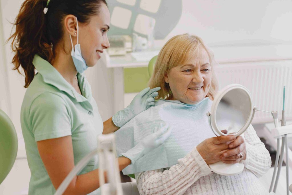 Senior patient reviewing dental treatment results with a dental professional.
