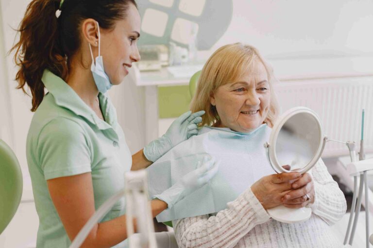 Senior patient reviewing dental treatment results with a dental professional.