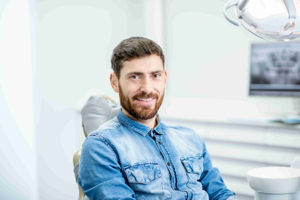 Smiling patient seated comfortably in a modern dental office.